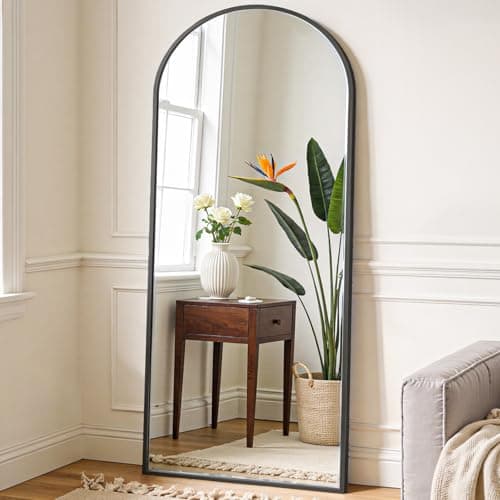 A round wall mirror in a styled entryway