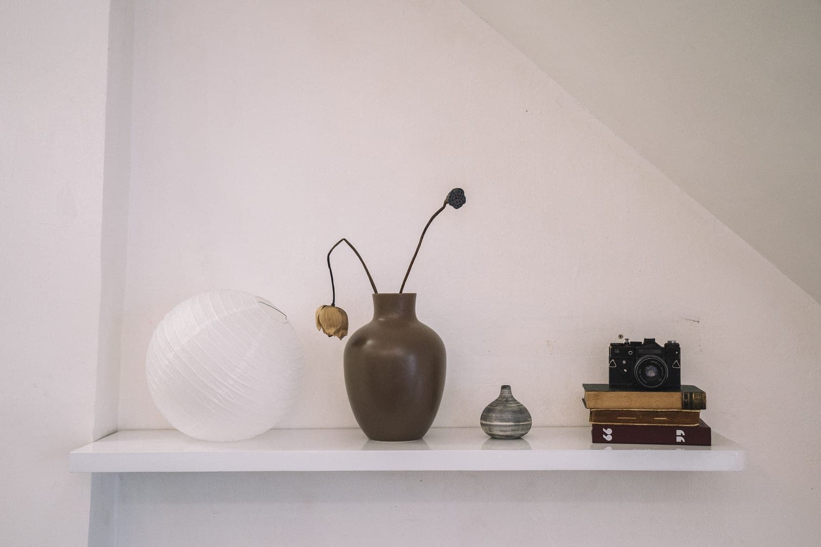 A warm, layered living room with a wood console, plants, and art