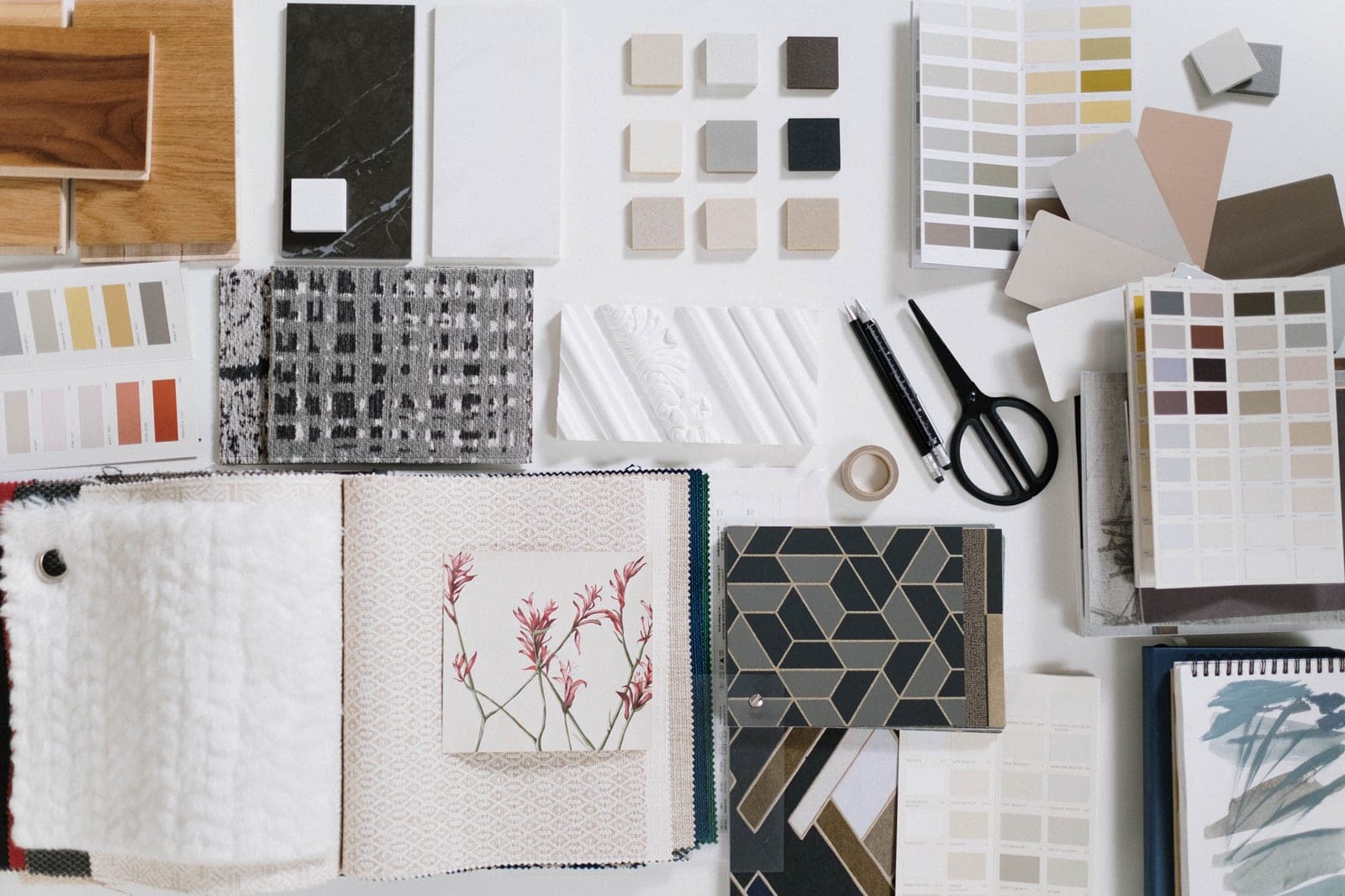 A desk with a mood board, fabric swatches, and a laptop