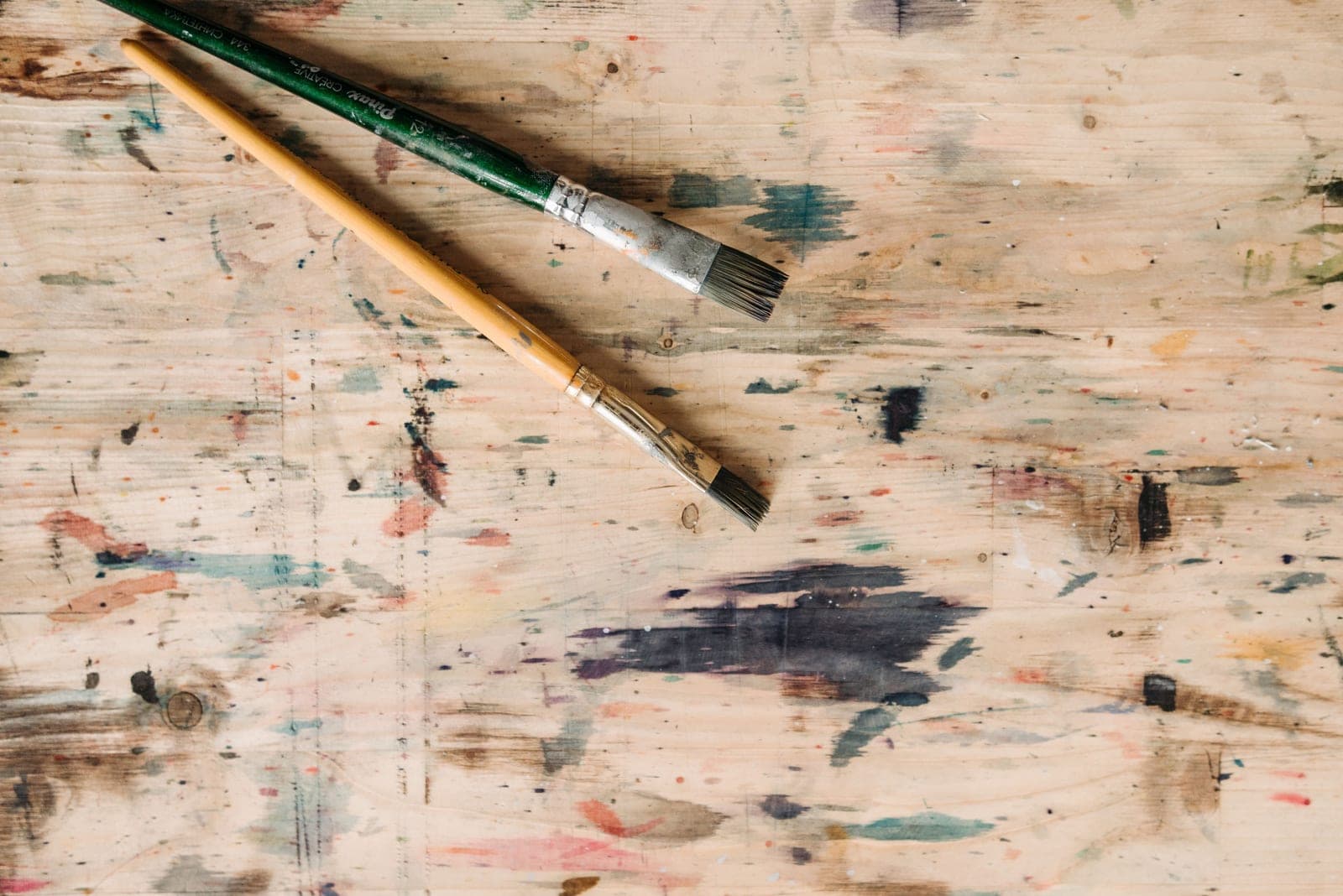 A workbench with paint, brushes, and a piece of furniture being refinished