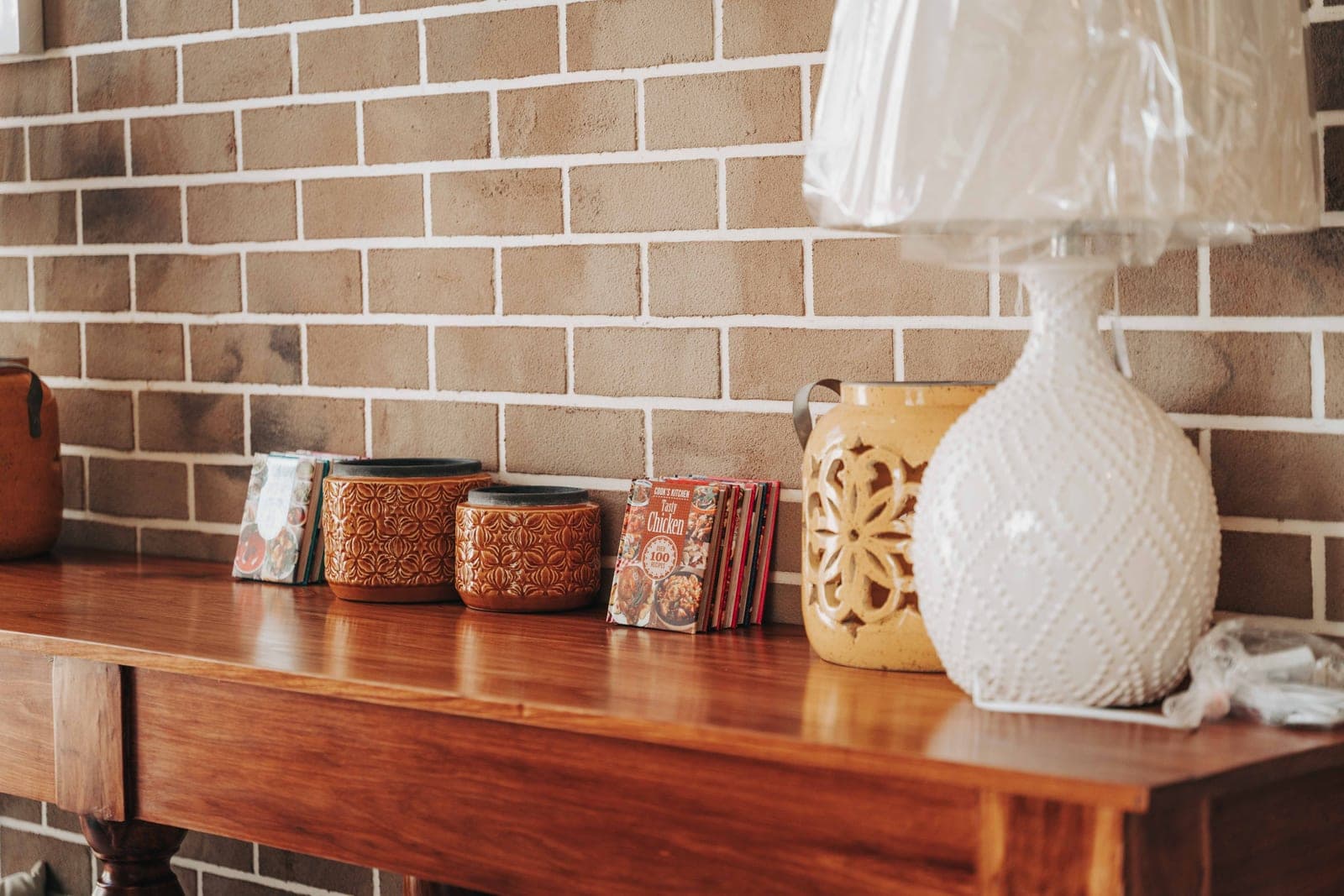 A styled shelf with vintage books, ceramics, and warm textiles