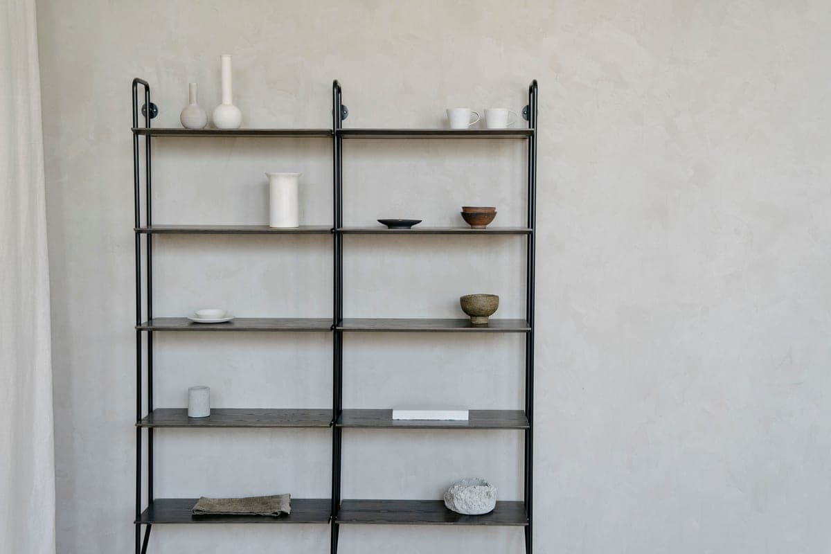 A styled shelf with vases, books, and ceramics