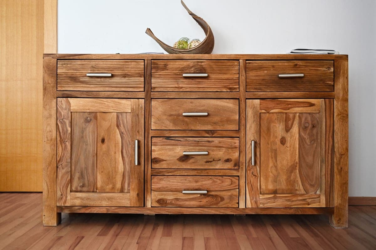 A wood dresser styled in a bedroom