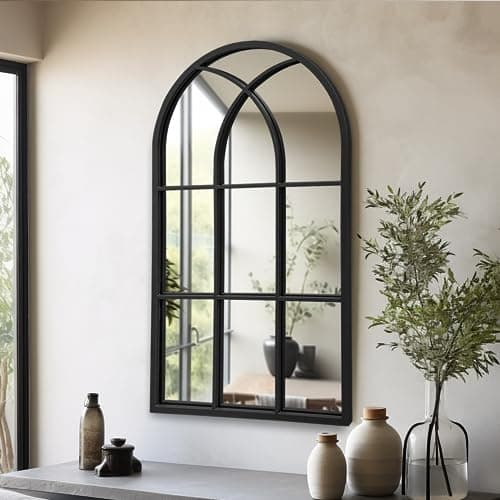 A round wall mirror in a styled entryway